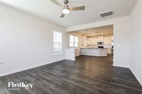 Simpsonville house for rent - A spacious room with wooden floors and a ceiling fan.