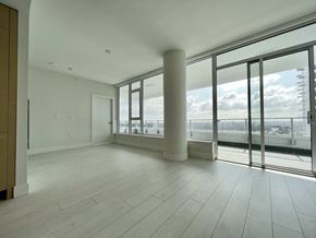 Vancouver apartment for rent - A large empty room with a view of the city through the windows.