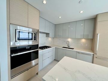Vancouver apartment for rent - A modern kitchen with a white countertop and stainless steel appliances.