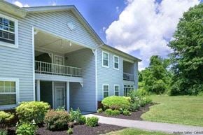 Tivoli apartment for rent - a blue house with a front porch and a lawn