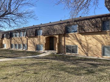 Kearney apartment for rent - a brick building with a brown door and a grassy yard