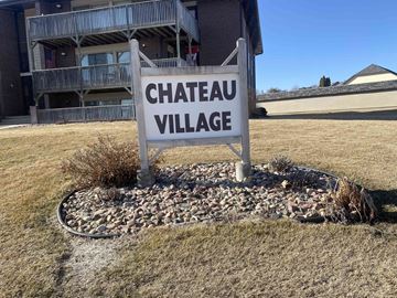 Kearney apartment for rent - a sign for chateau village in front of a house