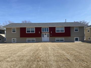 Kearney apartment for rent - a red and tan house with a yard in front of it