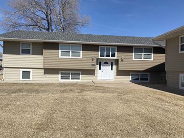 Kearney apartment for rent - a tan house with a white door and a grass yard