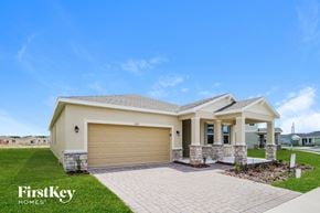 Kissimmee house for rent - A house with a garage door and a brick pathway leading to it.