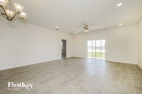 Kissimmee house for rent - A spacious room with a fan and a chandelier.