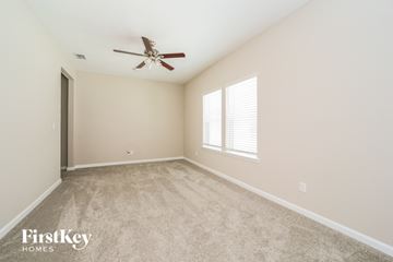 Yulee house for rent - a spacious living room with carpet and a ceiling fan