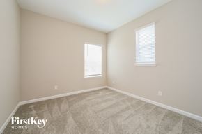 Yulee house for rent - a spacious room with carpet and two windows