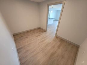 Bedford apartment for rent - A room with light wood flooring and white walls.