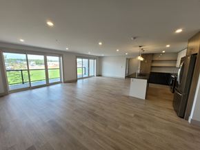 Bedford apartment for rent - A spacious room with wooden flooring and large windows.