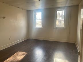 Chester apartment for rent - A room with two windows and wooden flooring.