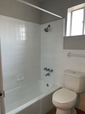 Austin apartment for rent - A white toilet sits next to a bathtub in a bathroom.