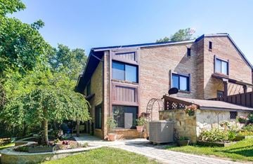 Columbia house for rent - A house with a stone wall and a garden in front.