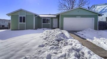 Broomfield house for rent - a green house with a driveway covered in snow