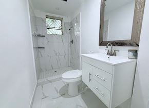 San Juan apartment for rent - A white bathroom with a toilet, sink, and shower.