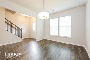 Greenville house for rent - A spacious room with wooden floors and a chandelier hanging from the ceiling.