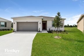 Bartow house for rent - a white house with a driveway and a garage door