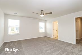 Simpsonville house for rent - A spacious room with a carpeted floor and a ceiling fan.