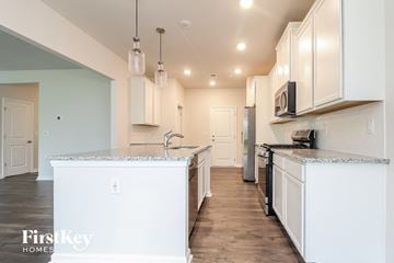 Simpsonville house for rent - a kitchen with white cabinets and a large counter top