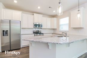 Simpsonville house for rent - a kitchen with white cabinets and a marble counter top