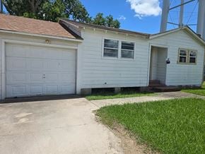 Bay City house for rent - A small white house with a garage door.