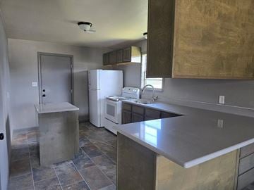 Bay City house for rent - A kitchen with a refrigerator, microwave, and oven.
