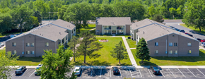 Newport apartment for rent - an aerial view of three buildings with a lawn and a parking lot