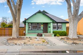 Sacramento house for rent - the front of a green house with two trees and a sidewalk