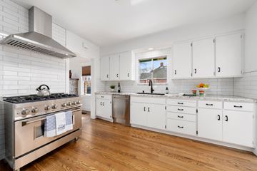 Sacramento house for rent - a renovated kitchen with white cabinets and stainless steel appliances