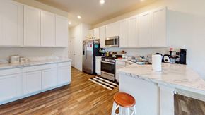 Crown Point house for rent - A kitchen with white cabinets and a wooden floor.
