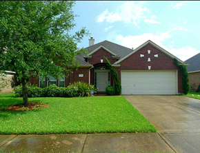 Pearland house for rent - a house with a driveway and a tree in front of it