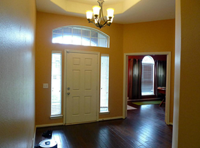 Pearland house for rent - an empty living room with a white door and a window