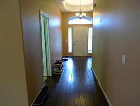 Pearland house for rent - an empty living room with a wooden floor and a white door