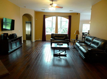 Pearland house for rent - a living room with leather furniture and a television