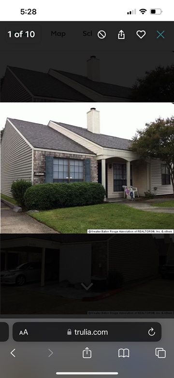 Baton Rouge apartment for rent - A house with a stone wall and a chimney is shown.