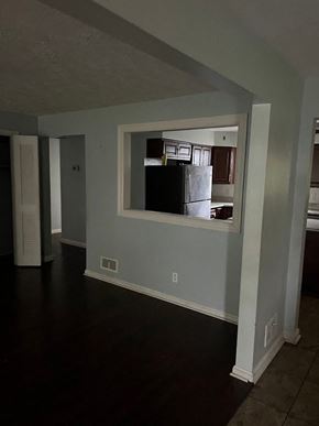 Cincinnati house for rent - an empty living room with a large window and a kitchen