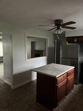 Cincinnati house for rent - an empty kitchen with a refrigerator and a ceiling fan