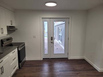 St Jacobs apartment for rent - A kitchen with white cabinets and a black stove top oven.