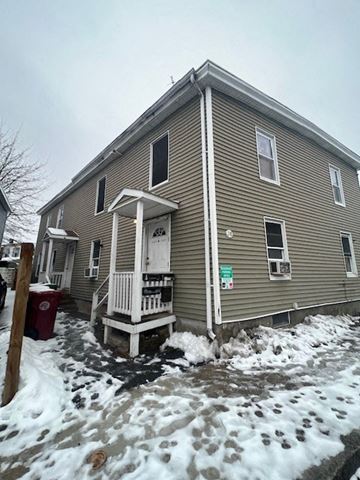 Lowell apartment for rent - A house with a brown siding and a white door.