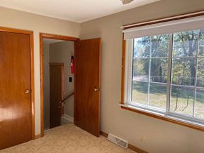 Waterloo house for rent - A room with a window and a view of a fence and trees outside.