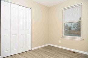 Fenton house for rent - a bedroom with a closet and a window and a door