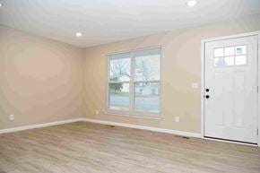 Fenton house for rent - an empty living room with a door and a window