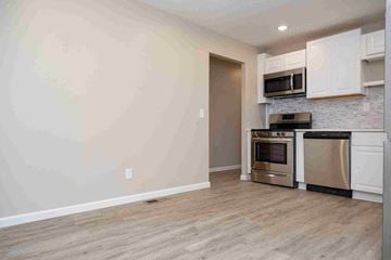Fenton house for rent - a kitchen with stainless steel appliances and white cabinets