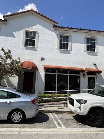 Miami apartment for rent - a white building with cars parked in front of it