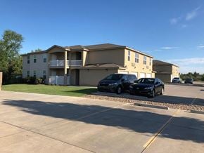 Dodge City apartment for rent - A black car is parked in a parking lot in front of a building.