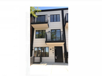 Brooklyn apartment for rent - the front of a white building with balconies and a black door