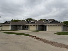 Dodge City apartment for rent - A grey house with a grey roof and grey garage doors.