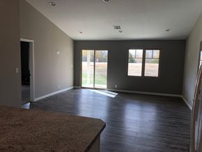 Dodge City apartment for rent - A room with a brown carpet and wooden flooring.