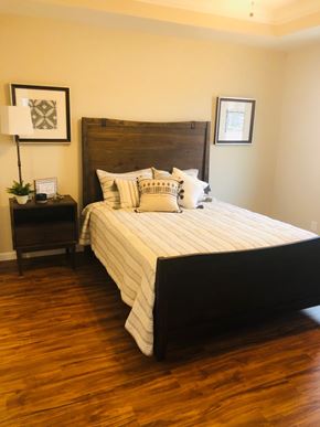 Dodge City apartment for rent - A bedroom with a large bed and a wooden headboard.