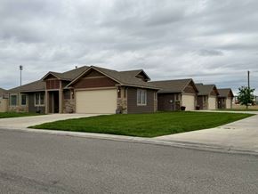Dodge City apartment for rent - A row of houses with a cloudy sky above them.
